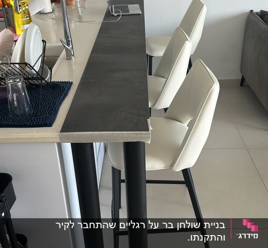 מטבח עם דלפק וכיסאות בר לבנים